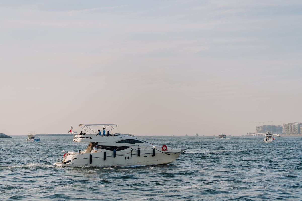 Luxury motor yacht cruising calm waters with coastal skyline